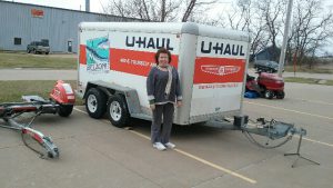 woman standing next to rentable u-haul trailer