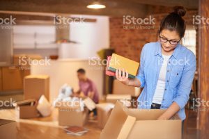 woman packing boxes with books and posessions
